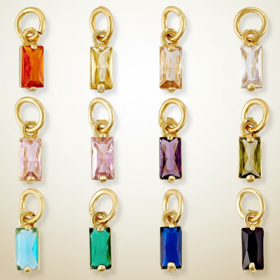 Gold-rimmed gemstone pendants in various colors on a light background