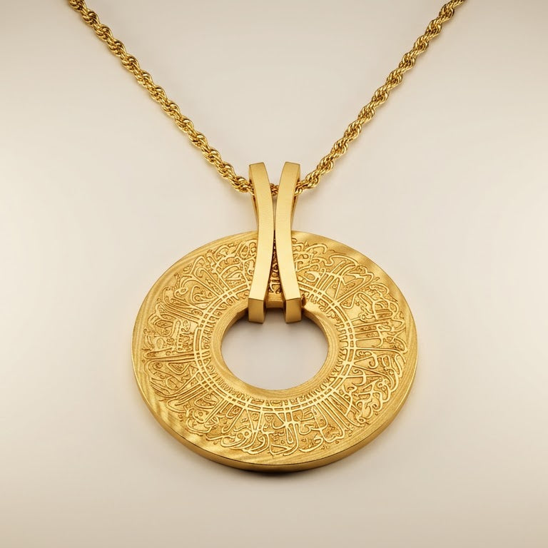 Gold pendant with engraved ayatul kursi on a light background