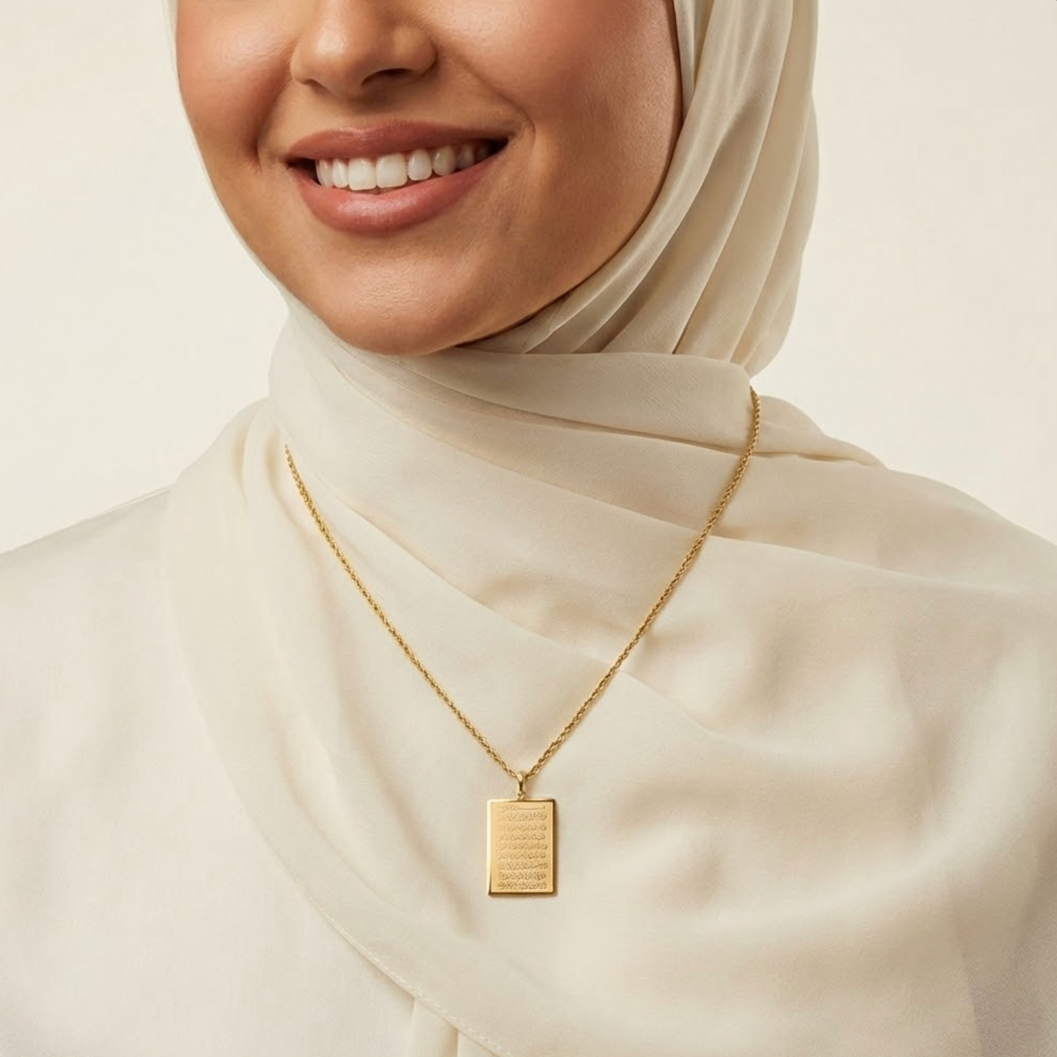 Woman wearing a gold ayatul kursi necklace with a pendant on a plain background