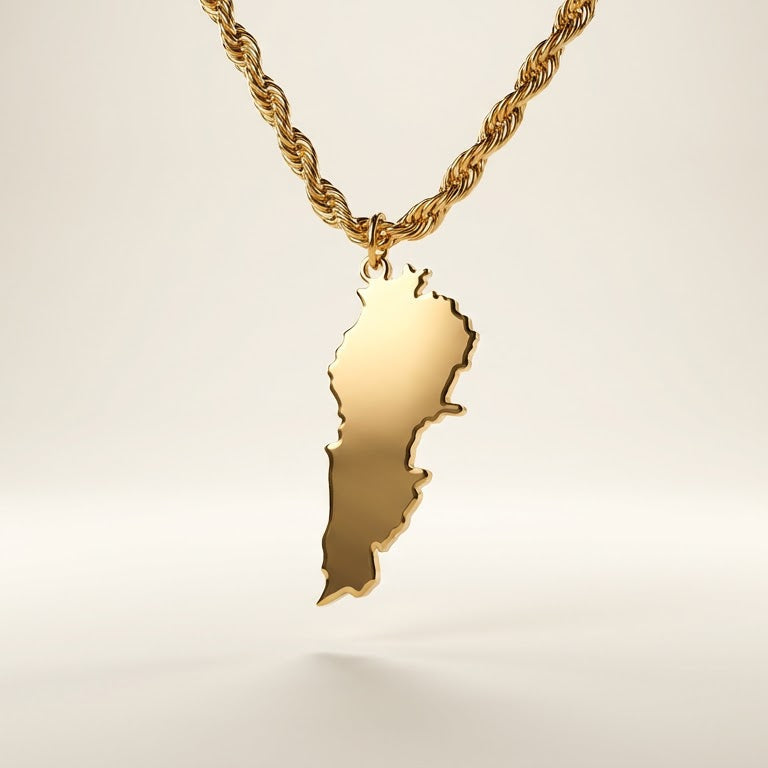 Gold necklace with a lebanon shaped pendant on a light background