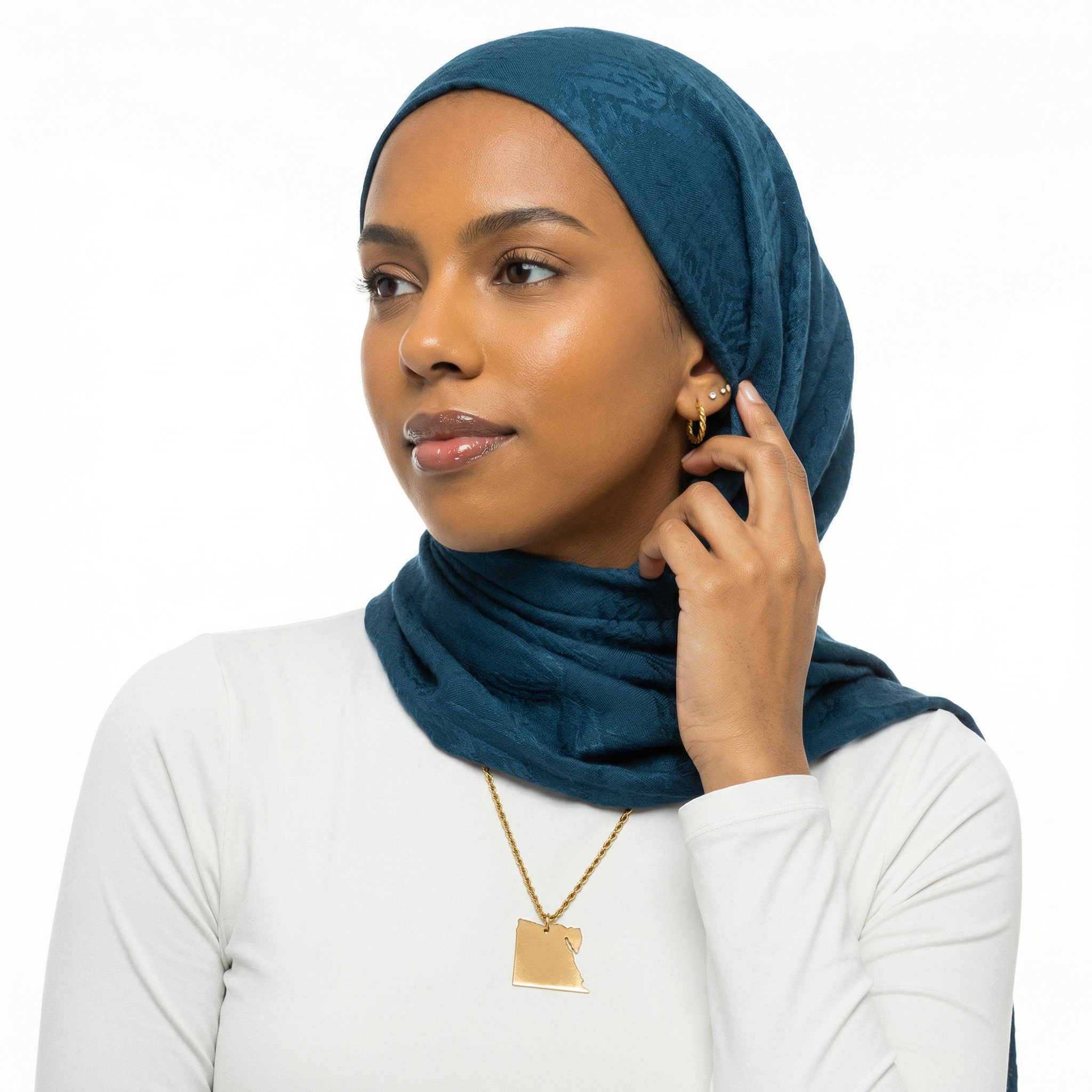 Woman wearing a blue hijab and white top on a white background