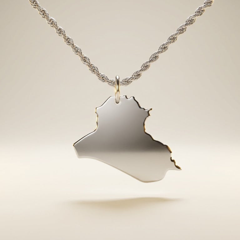 Silver necklace with a pendant shaped like the country of Iraq on a light beige background