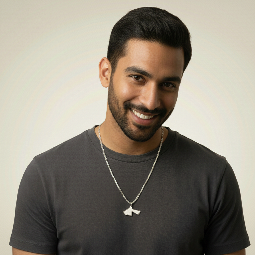Man wearing a dark gray t-shirt with a necklace against a neutral background
