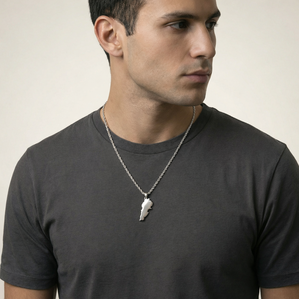 Man wearing a dark gray t-shirt with a necklace featuring a lebanon pendant.