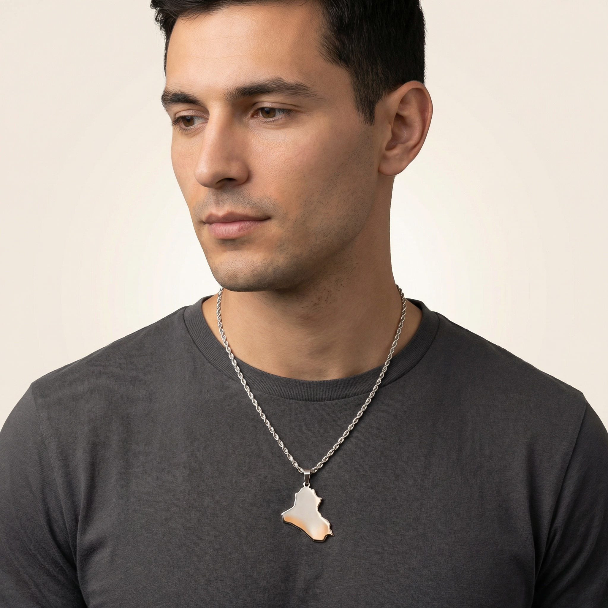 Man wearing a necklace with a pendant on a plain background