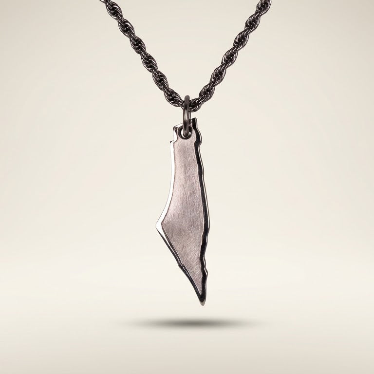 silver necklace with a pendant shaped like the country on a light beige background